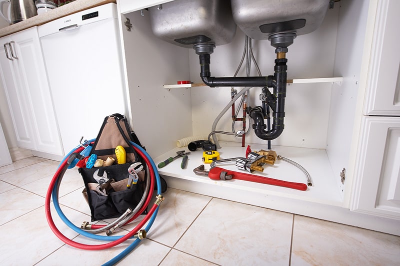 Image of the kitchen sink plumbing; emergency repair work completed by Kaier Property Management.